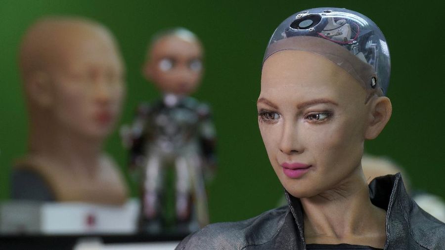 David Hanson, left, creator of Sophia, shows a work of Sophia at his studio in Hong Kong on March 29, 2021. Sophia is a robot of many talents — she speaks, jokes, sings and even makes art. In March, she caused a stir in the art world when a digital work she created as part of a collaboration was sold at an auction for $688,888 in the form of a non-fungible token (NFT).WLD(AP Photo/Vincent Yu)