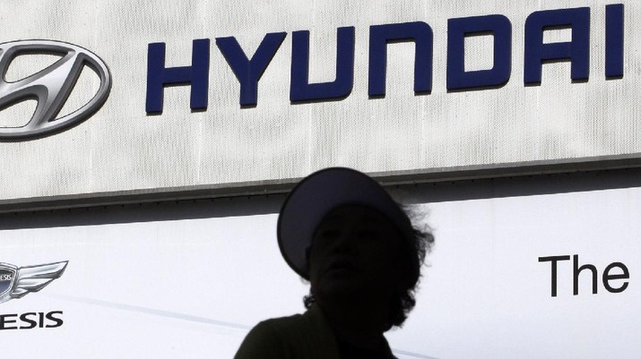 A woman is silhouetted near the Hyundai Motor's logo at the company's showroom in Seoul, South Korea, Thursday, April 26, 2012. The South Korean top automaker said Thursday its first quarter earnings rose 30.6 percent from a year earlier. (AP Photo/Lee Jin-man)