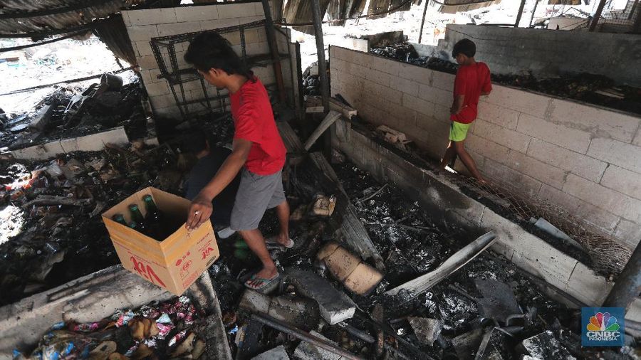 Sejumlah pedagang mengambil barang sisa kebakaran di Pasar Kambing, Tanah Abang, Jakarta (9/4/2021). Pasar kambing terbakar pada Kamis (8/4) sore, tampak semua  bangunan semi permanen ludes terbakar. Pantauan CNBC Indonesia petugas pemadam kebakaran masih mendinginkan api dilokasi terbakarnya pasar. Herman (39) 