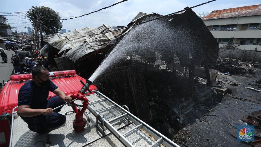 Sejumlah pedagang mengambil barang sisa kebakaran di Pasar Kambing, Tanah Abang, Jakarta (9/4/2021). Pasar kambing terbakar pada Kamis (8/4) sore, tampak semua  bangunan semi permanen ludes terbakar. Pantauan CNBC Indonesia petugas pemadam kebakaran masih mendinginkan api dilokasi terbakarnya pasar. Herman (39) 