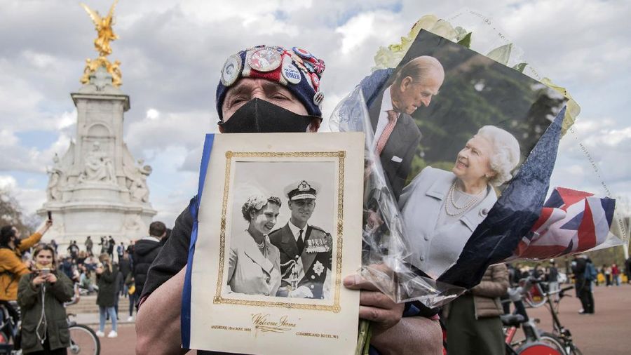 Royal superfan John Loughrey outside Buckingham Palace following the announcement of the death of Britain's Prince Philip, in London, Friday, April 9, 2021. Prince Philip, the irascible and tough-minded husband of Queen Elizabeth II who spent more than seven decades supporting his wife in a role that both defined and constricted his life, has died, Buckingham Palace said Friday. He was 99. (Ian West/PA via AP)
