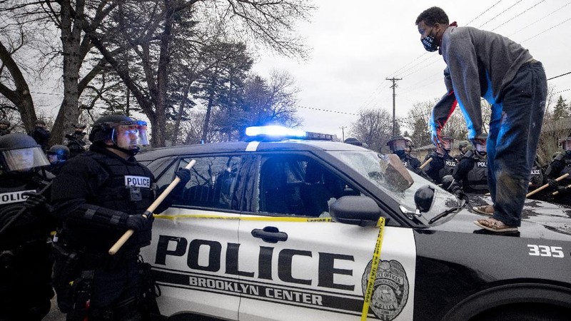 Warga merusak mobil polisi setelah penembakan fatal seorang warga kulit hitam di Minneapolis, AS. (AP/Christian Monterrosa)