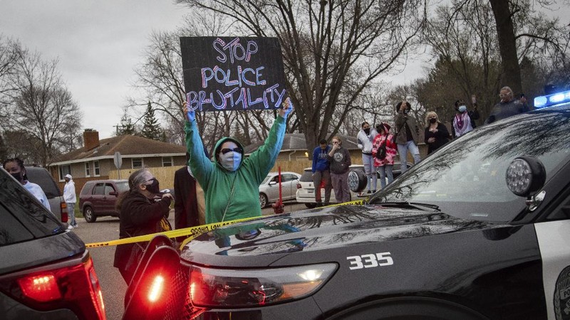 Warga merusak mobil polisi setelah penembakan fatal seorang warga kulit hitam di Minneapolis, AS. (AP/Christian Monterrosa)