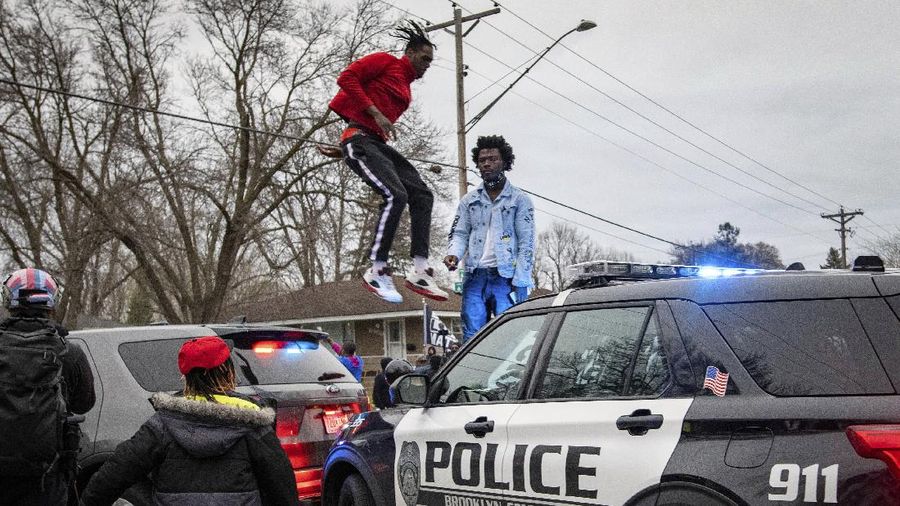 Warga merusak mobil polisi setelah penembakan fatal seorang warga kulit hitam di Minneapolis, AS. (AP/Christian Monterrosa)