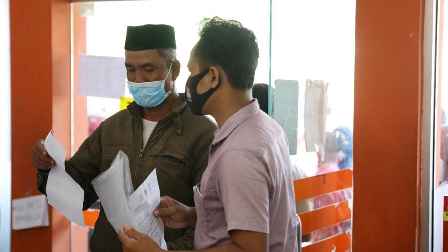 Warga Desa Cihowe, Ciseeng  mengantre saat pengambilan Bantuan Sosial Tunai (BST) di Kantor Pos Indonesia, dikawasan Parung, Bogor, Jawa Barat, Rabu (14/4/2021). Kementerian Sosial menekankan Bantuan Sosial Tunai (BST) bagi terdampak Covid-19 tak akan diperpanjang. BST terakhir disalurkan pada April 2021.