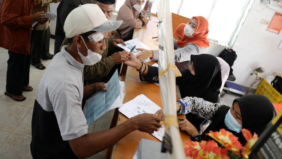 Warga Desa Cihowe, Ciseeng mengantre saat pengambilan Bantuan Sosial Tunai (BST) di Kantor Pos Indonesia, dikawasan Parung, Bogor, Jawa Barat, Rabu (14/4/2021). Kementerian Sosial menekankan Bantuan Sosial Tunai (BST) bagi terdampak Covid-19 tak akan diperpanjang. BST terakhir disalurkan pada April 2021.