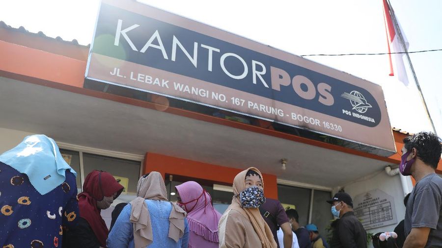 Warga Desa Cihowe, Ciseeng  mengantre saat pengambilan Bantuan Sosial Tunai (BST) di Kantor Pos Indonesia, dikawasan Parung, Bogor, Jawa Barat, Rabu (14/4/2021). Kementerian Sosial menekankan Bantuan Sosial Tunai (BST) bagi terdampak Covid-19 tak akan diperpanjang. BST terakhir disalurkan pada April 2021.