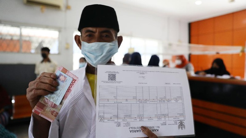 Warga Desa Cihowe, Ciseeng  mengantre saat pengambilan Bantuan Sosial Tunai (BST) di Kantor Pos Indonesia, dikawasan Parung, Bogor, Jawa Barat, Rabu (14/4/2021). Kementerian Sosial menekankan Bantuan Sosial Tunai (BST) bagi terdampak Covid-19 tak akan diperpanjang. BST terakhir disalurkan pada April 2021.