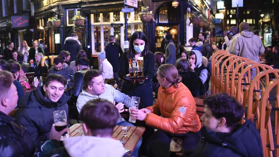 Orang-orang menikmati matahari di atap bar Skylight setelah pemerintah melonggarkan lockdown Covid-19 di London, Inggris. AP/Alberto Pezzali