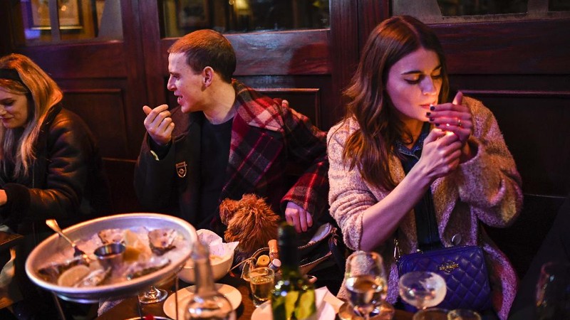 Orang-orang menikmati matahari di atap bar Skylight setelah pemerintah melonggarkan lockdown Covid-19 di London, Inggris. AP/Alberto Pezzali