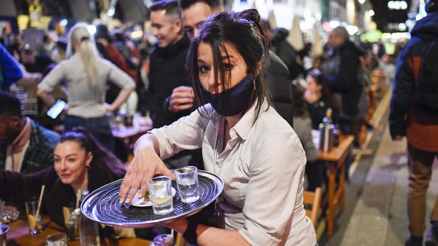 Orang-orang menikmati matahari di atap bar Skylight setelah pemerintah melonggarkan lockdown Covid-19 di London, Inggris. AP/Alberto Pezzali