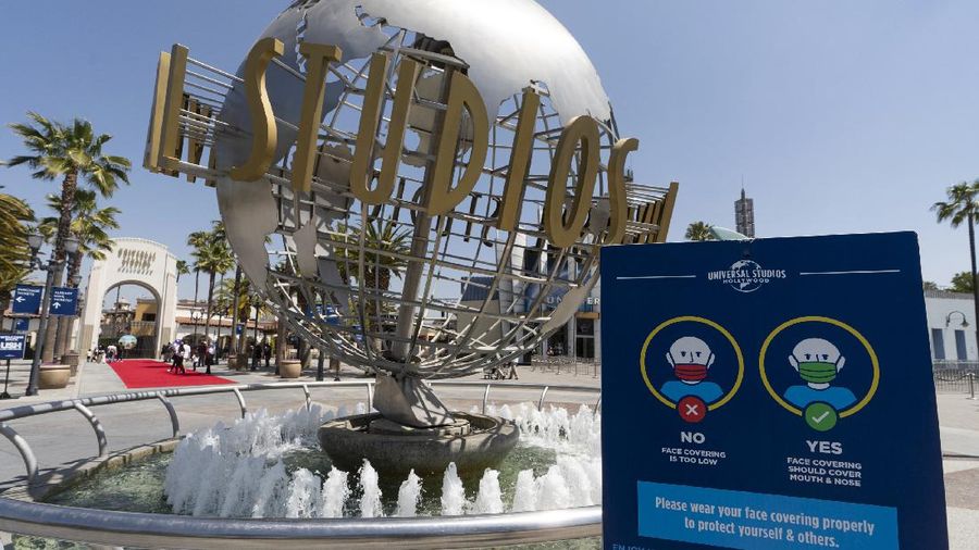 Young people wear mandatory face masks at the Wizarding World of Harry Potter at Universal Studios Hollywood theme park as it officially reopens to the public at 25% capacity with COVID-19 protocols in place in Los Angeles, Friday, April 16, 2021. (AP Photo/Damian Dovarganes)