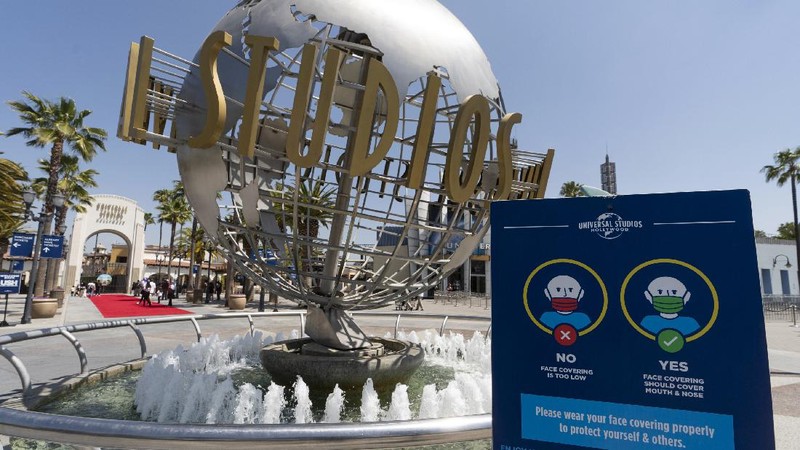 Young people wear mandatory face masks at the Wizarding World of Harry Potter at Universal Studios Hollywood theme park as it officially reopens to the public at 25% capacity with COVID-19 protocols in place in Los Angeles, Friday, April 16, 2021. (AP Photo/Damian Dovarganes)