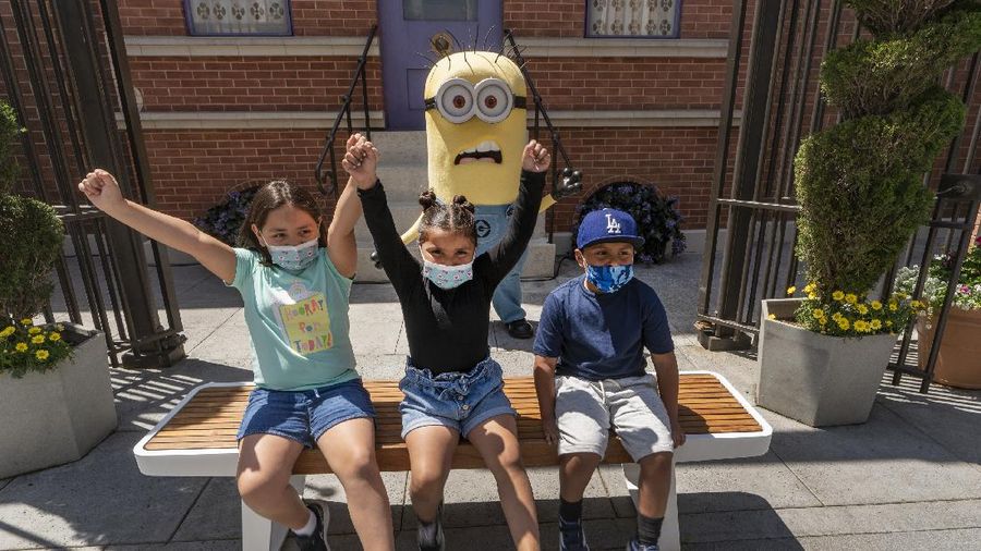 Young people wear mandatory face masks at the Wizarding World of Harry Potter at Universal Studios Hollywood theme park as it officially reopens to the public at 25% capacity with COVID-19 protocols in place in Los Angeles, Friday, April 16, 2021. (AP Photo/Damian Dovarganes)