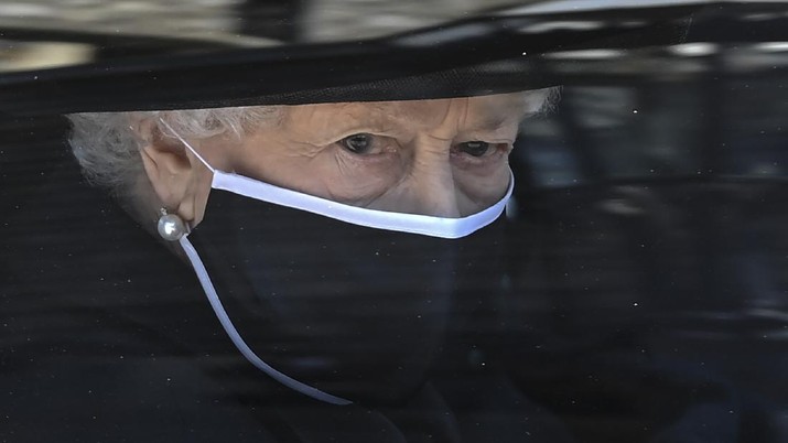 Britain's Queen Elizabeth II follows the coffin in a car as it makes it's way past the Round Tower during the funeral of Britain's Prince Philip inside Windsor Castle in Windsor, England Saturday April 17, 2021. (Leon Neal/Pool via AP)