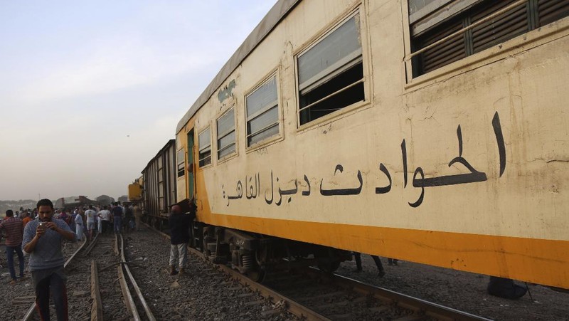 A crane is used to lift a part of a passenger train that derailed injuring some 100 people, near Banha, Qalyubia province, Egypt, Sunday, April 18, 2021. At least eight train wagons ran off the railway, the provincial governor's office said in a statement. (AP Photo/Fadel Dawood)
