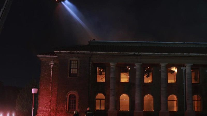 A helicopter drops water over a fire at Rhodes Memorial on Table Mountain, Cape Town, South Africa, Sunday, April 18, 2021. A wildfire raging on the slopes of the mountain forced the evacuation of students from the University of Cape Town. (AP Photo/Nardus Engelbrecht)