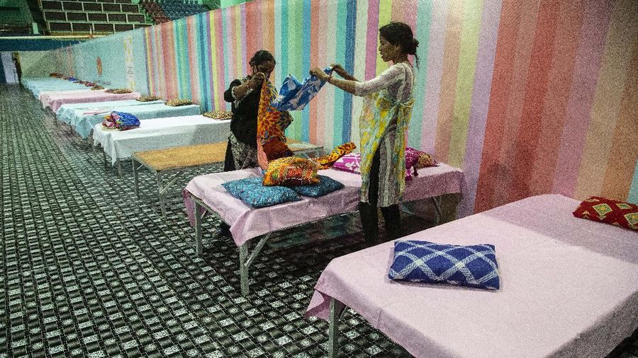 Workers arrange beds at a COVID-19 treatment facility newly set up at an indoor stadium in Gauhati, India, Monday, April 19, 2021. India now has reported more than 15 million coronavirus infections, a total second only to the United States. (AP Photo/Anupam Nath)