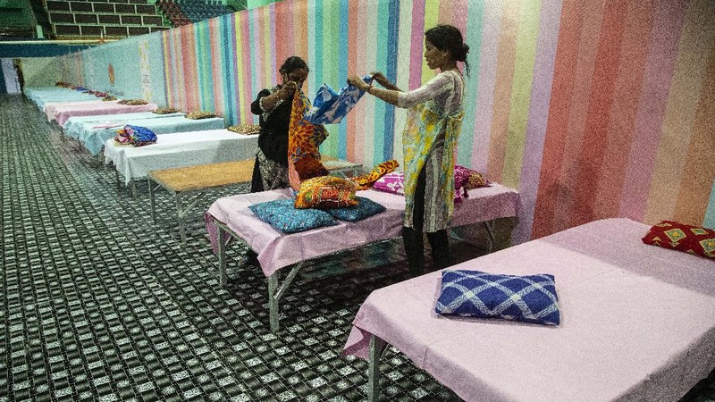 Workers arrange beds at a COVID-19 treatment facility newly set up at an indoor stadium in Gauhati, India, Monday, April 19, 2021. India now has reported more than 15 million coronavirus infections, a total second only to the United States. (AP Photo/Anupam Nath)