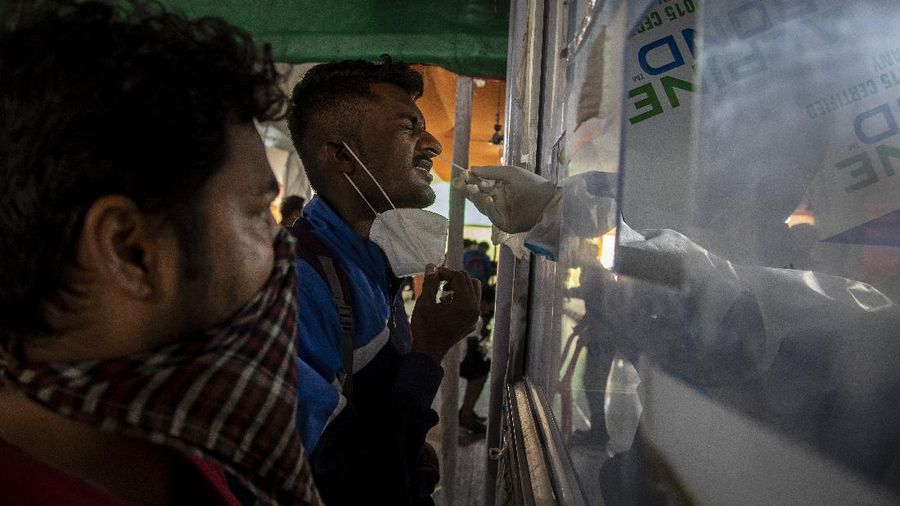 Workers arrange beds at a COVID-19 treatment facility newly set up at an indoor stadium in Gauhati, India, Monday, April 19, 2021. India now has reported more than 15 million coronavirus infections, a total second only to the United States. (AP Photo/Anupam Nath)
