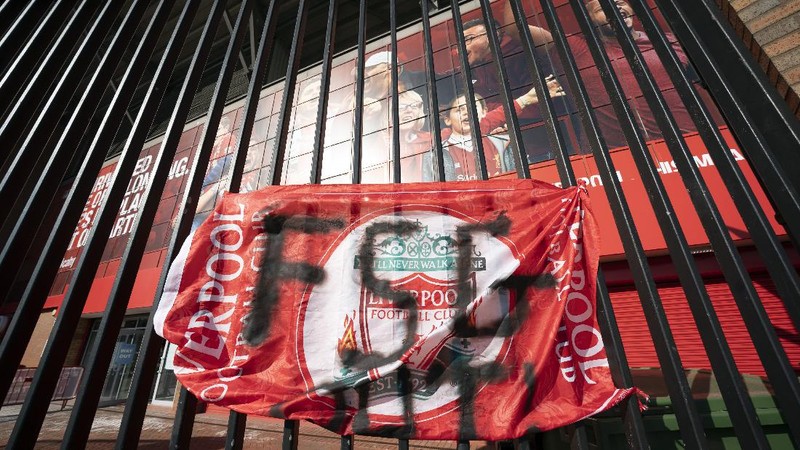 Football supporters place a protest banner outside Manchester United's Old Trafford Stadium, Manchester, England, Monday, April 19, 2021, opposing the formation of the European Super League. Players at the 12 clubs setting up their own Super League could be banned from this year’s European Championship and next year’s World Cup, UEFA President Aleksander Ceferin said Monday. (AP Photo/Jon Super)