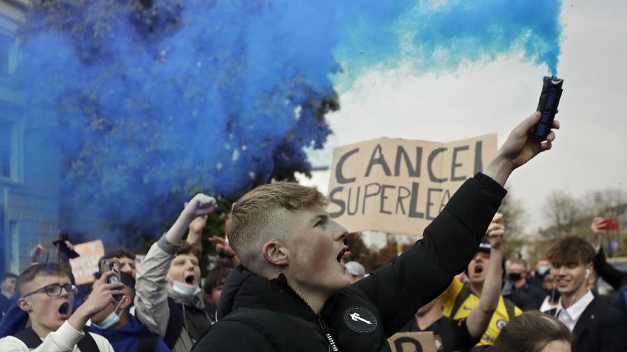 Football supporters place a protest banner outside Manchester United's Old Trafford Stadium, Manchester, England, Monday, April 19, 2021, opposing the formation of the European Super League. Players at the 12 clubs setting up their own Super League could be banned from this year’s European Championship and next year’s World Cup, UEFA President Aleksander Ceferin said Monday. (AP Photo/Jon Super)