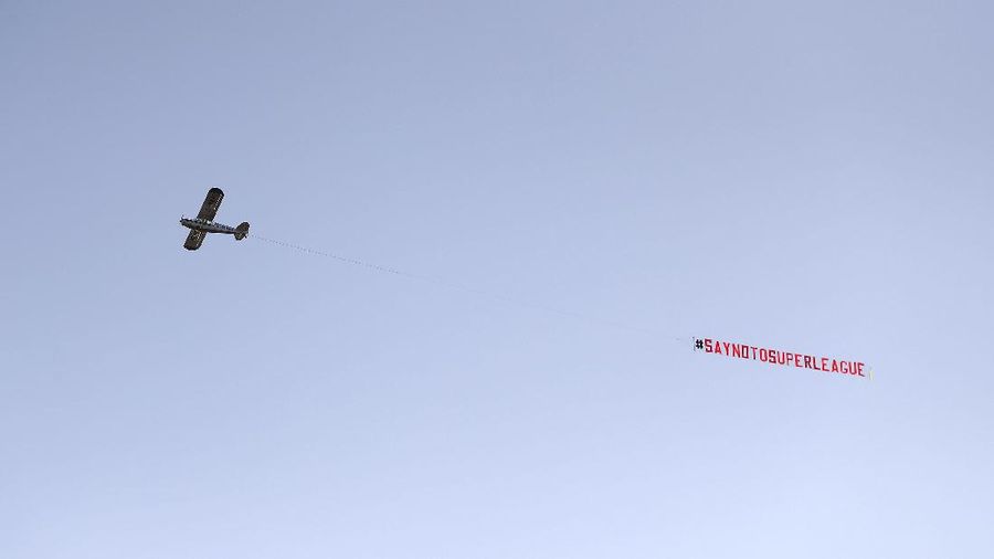 Football supporters place a protest banner outside Manchester United's Old Trafford Stadium, Manchester, England, Monday, April 19, 2021, opposing the formation of the European Super League. Players at the 12 clubs setting up their own Super League could be banned from this year’s European Championship and next year’s World Cup, UEFA President Aleksander Ceferin said Monday. (AP Photo/Jon Super)