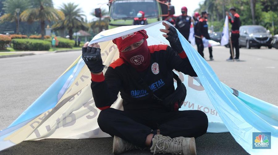 Sejumlah masa aksi buruh memakai hazmat dan membawa keranda mayat menggelar taterikal di Patung Kuda Arjuna Wiwaha, Jakarta, Rabu (21/4/2021). (CNBC Indonesia/Tri Susilo)