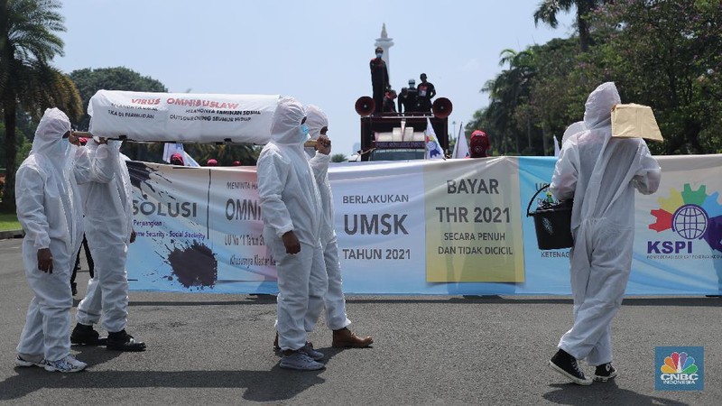 Sejumlah masa aksi buruh memakai hazmat dan membawa keranda mayat menggelar taterikal di Patung Kuda Arjuna Wiwaha, Jakarta, Rabu (21/4/2021). (CNBC Indonesia/Tri Susilo)