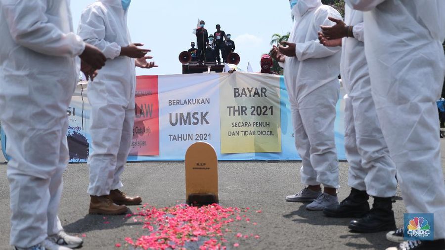 Sejumlah masa aksi buruh memakai hazmat dan membawa keranda mayat menggelar taterikal di Patung Kuda Arjuna Wiwaha, Jakarta, Rabu (21/4/2021). (CNBC Indonesia/Tri Susilo)