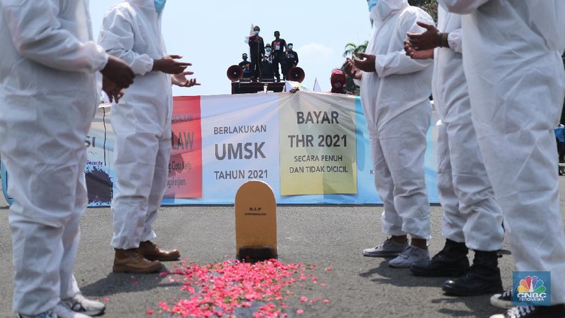 Sejumlah masa aksi buruh memakai hazmat dan membawa keranda mayat menggelar taterikal di Patung Kuda Arjuna Wiwaha, Jakarta, Rabu (21/4/2021). (CNBC Indonesia/Tri Susilo)