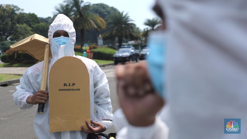 Sejumlah masa aksi buruh memakai hazmat dan membawa keranda mayat menggelar taterikal di Patung Kuda Arjuna Wiwaha, Jakarta, Rabu (21/4/2021). (CNBC Indonesia/Tri Susilo)