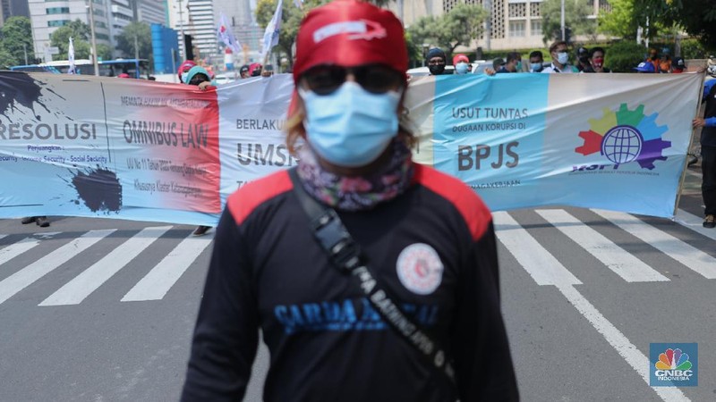 Sejumlah masa aksi buruh memakai hazmat dan membawa keranda mayat menggelar taterikal di Patung Kuda Arjuna Wiwaha, Jakarta, Rabu (21/4/2021). (CNBC Indonesia/Tri Susilo)