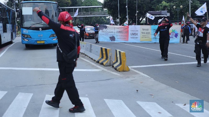 Sejumlah masa aksi buruh memakai hazmat dan membawa keranda mayat menggelar taterikal di Patung Kuda Arjuna Wiwaha, Jakarta, Rabu (21/4/2021). (CNBC Indonesia/Tri Susilo)