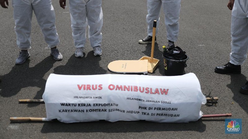 Sejumlah masa aksi buruh memakai hazmat dan membawa keranda mayat menggelar taterikal di Patung Kuda Arjuna Wiwaha, Jakarta, Rabu (21/4/2021). (CNBC Indonesia/Tri Susilo)