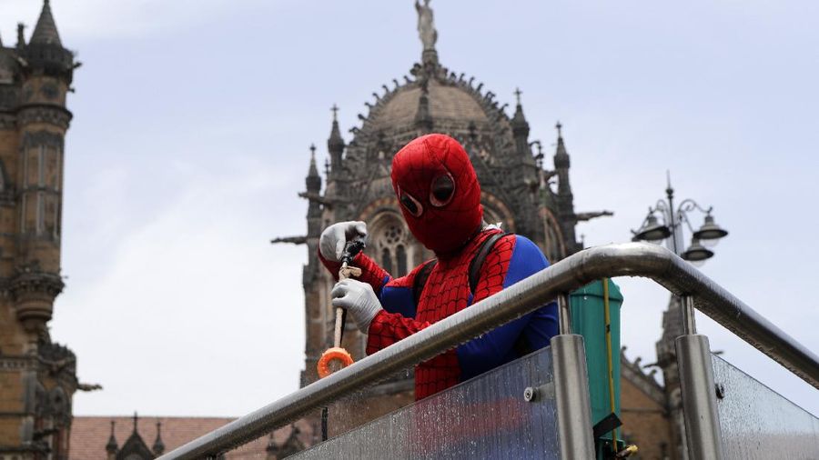 Indian social worker Ashok Kurmi dressed as spider man sanitizes the area around Chhatrapati Shivaji Maharaj train Terminus during a lockdown imposed to curb the spread of COVID-19 in Mumbai, India, Wednesday, April 21, 2021. (AP Photo/Rajanish Kakade)