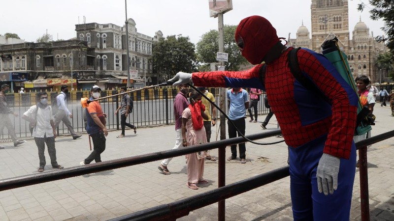 Indian social worker Ashok Kurmi dressed as spider man sanitizes the area around Chhatrapati Shivaji Maharaj train Terminus during a lockdown imposed to curb the spread of COVID-19 in Mumbai, India, Wednesday, April 21, 2021. (AP Photo/Rajanish Kakade)