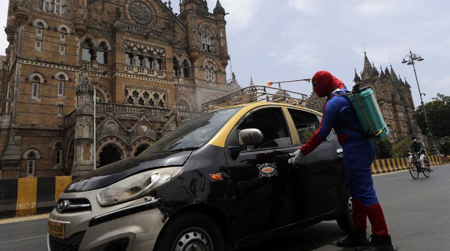 Indian social worker Ashok Kurmi dressed as spider man sanitizes the area around Chhatrapati Shivaji Maharaj train Terminus during a lockdown imposed to curb the spread of COVID-19 in Mumbai, India, Wednesday, April 21, 2021. (AP Photo/Rajanish Kakade)