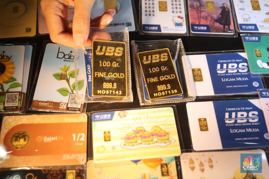 Pegawai merapikan emas batangan di Galeri 24 Pegadaian, Jakarta, Kamis (22/4/2021). Harga emas batangan yang dijual Pegadaian mengalami penurunan nyaris di semua jenis dan ukuran /satuan.  (CNBC Indonesia/Tri Susilo)