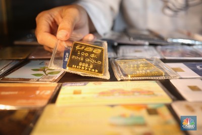 Pegawai merapikan emas batangan di Galeri 24 Pegadaian, Jakarta, Kamis (22/4/2021). Harga emas batangan yang dijual Pegadaian mengalami penurunan nyaris di semua jenis dan ukuran /satuan.  (CNBC Indonesia/Tri Susilo)