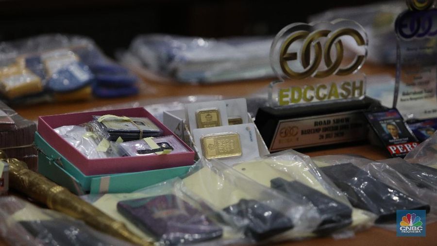 Petugas Bareskrim Polri merapihkan narang bukti hasil tindak pidana kasus dugaan penipuan investasi EDCCash saat gelar perkara di Bareskrim Polri , Jakarta, Kamis (22/4/2021). Total ada 6 orang ditetapkan sebagai tersangka, termasuk CEO EDCCash. (²©²ÊÍøÕ¾/Andrean Kristianto)