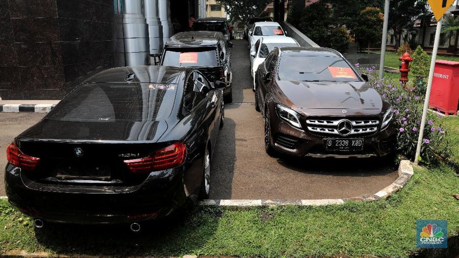 Petugas Bareskrim Polri merapihkan narang bukti hasil tindak pidana kasus dugaan penipuan investasi EDCCash saat gelar perkara di Bareskrim Polri , Jakarta, Kamis (22/4/2021). Total ada 6 orang ditetapkan sebagai tersangka, termasuk CEO EDCCash. (CNBC Indonesia/Andrean Kristianto)