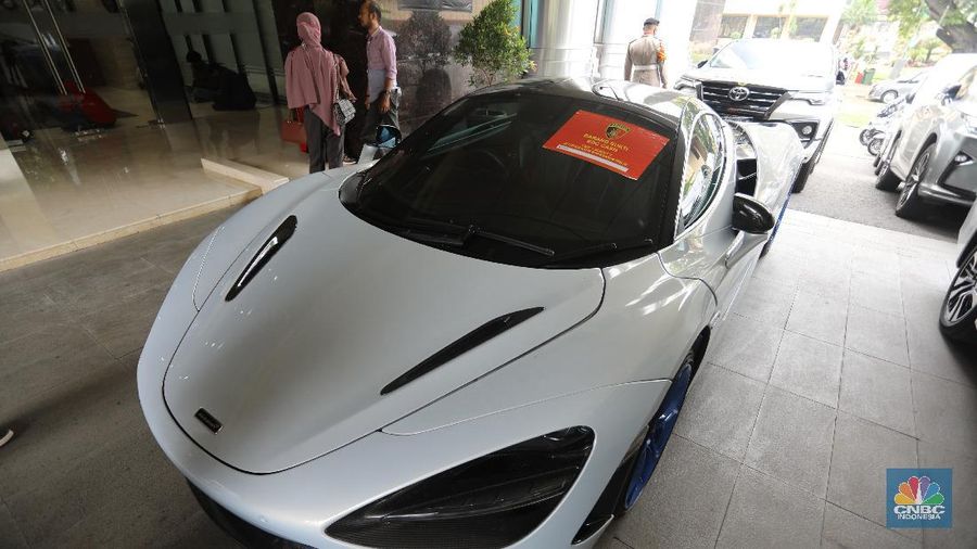 Petugas Bareskrim Polri merapihkan narang bukti hasil tindak pidana kasus dugaan penipuan investasi EDCCash saat gelar perkara di Bareskrim Polri , Jakarta, Kamis (22/4/2021). Total ada 6 orang ditetapkan sebagai tersangka, termasuk CEO EDCCash. (CNBC Indonesia/Andrean Kristianto)