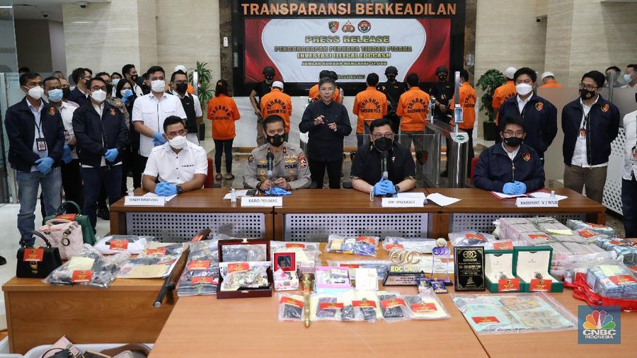Petugas Bareskrim Polri merapihkan narang bukti hasil tindak pidana kasus dugaan penipuan investasi EDCCash saat gelar perkara di Bareskrim Polri , Jakarta, Kamis (22/4/2021). Total ada 6 orang ditetapkan sebagai tersangka, termasuk CEO EDCCash. (CNBC Indonesia/Andrean Kristianto)