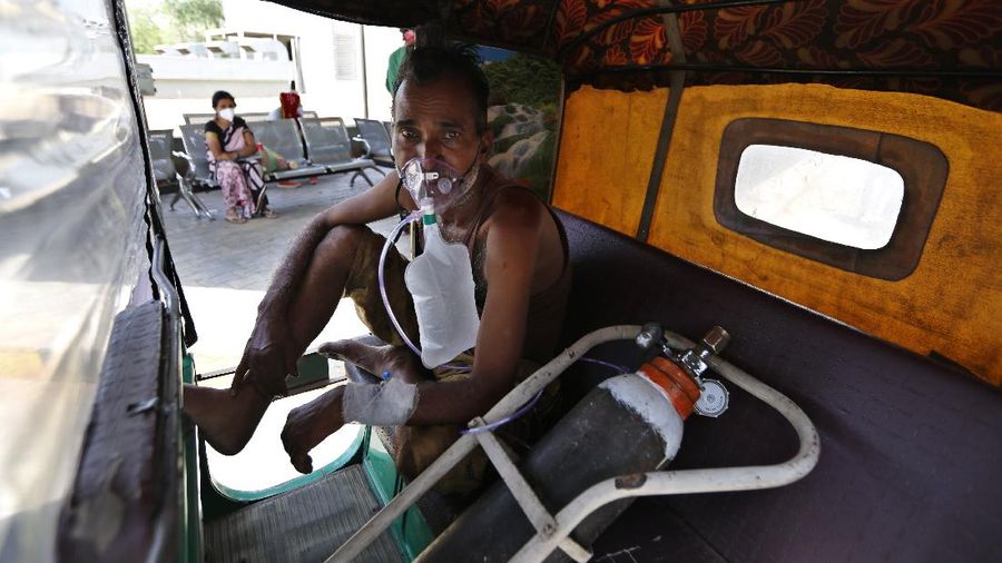 A patient breathes with the help of oxygen provided by a Gurdwara, Sikh place of worship, inside a car in New Delhi, India, Saturday, April 24, 2021. India’s medical oxygen shortage has become so dire that this gurdwara began offering free breathing sessions with shared tanks to COVID-19 patients waiting for a hospital bed. They arrive in their cars, on foot or in three-wheeled taxis, desperate for a mask and tube attached to the precious oxygen tanks outside the gurdwara in a neighborhood outside New Delhi. (AP Photo/Altaf Qadri)