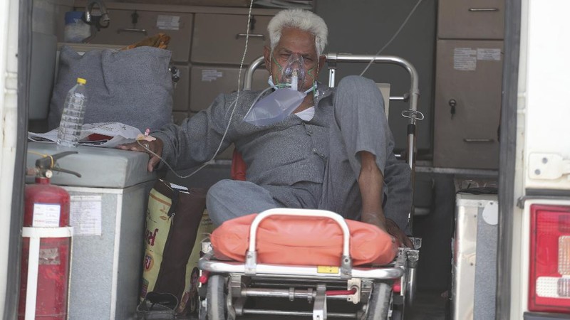 A COVID-19 patient wearing oxygen mask waits inside an auto rickshaw to be attended and admitted in a dedicated COVID-19 government hospital in Ahmedabad, India, Thursday, April 22, 2021. India reported a global record of more than 314,000 new infections Thursday as a grim coronavirus surge in the world's second-most populous country sends more and more sick people into a fragile health care system critically short of hospital beds and oxygen. (AP Photo/Ajit Solanki)