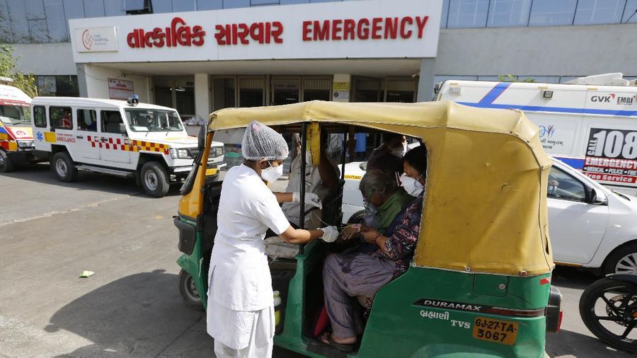 A COVID-19 patient wearing oxygen mask waits inside an auto rickshaw to be attended and admitted in a dedicated COVID-19 government hospital in Ahmedabad, India, Thursday, April 22, 2021. India reported a global record of more than 314,000 new infections Thursday as a grim coronavirus surge in the world's second-most populous country sends more and more sick people into a fragile health care system critically short of hospital beds and oxygen. (AP Photo/Ajit Solanki)