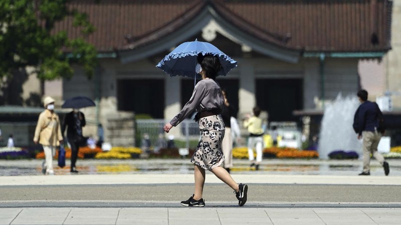 People wearing face masks to help curb the spread of the coronavirus walk towards a train station in Tokyo on Friday, April 23, 2021. (AP Photo/Hiro Komae)