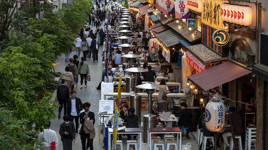 People sit in the outdoor seating areas of restaurants and bars Tuesday, April 20, 2021, in Tokyo. (AP Photo/Kiichiro Sato)