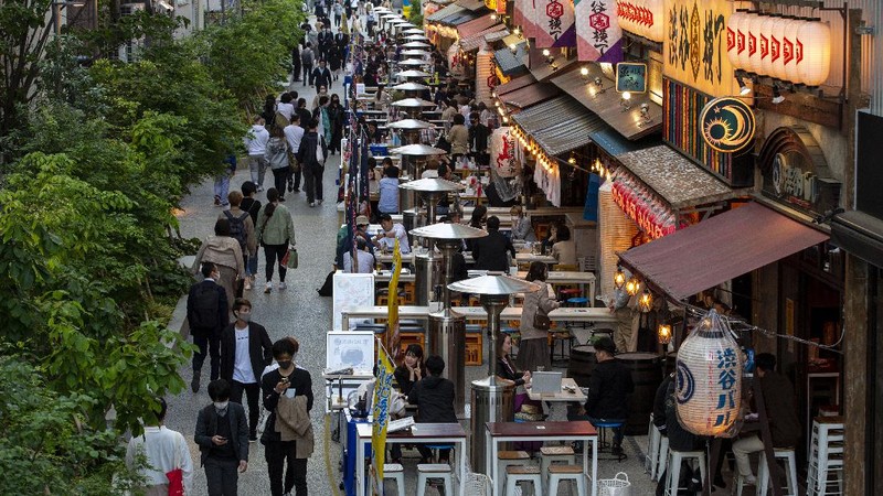 People wearing face masks to help curb the spread of the coronavirus walk towards a train station in Tokyo on Friday, April 23, 2021. (AP Photo/Hiro Komae)